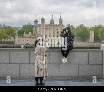 Londra, Regno Unito. 17 maggio 2021. Le restrizioni del Covid governativo si sollevano gradualmente e i turisti tornano lentamente a Londra, due giovani donne che scattano foto telefoniche sullo sfondo della Torre di Londra. Credit: Malcolm Park/Alamy Live News Foto Stock