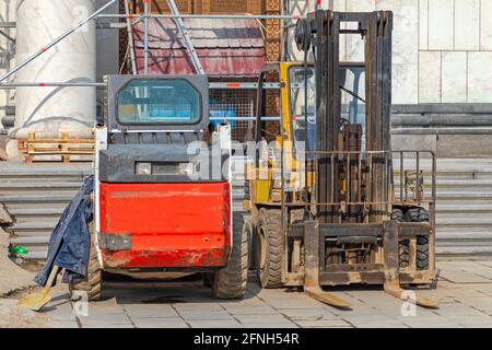 Minipala caricatrice e carrello elevatore a forche nel cantiere edile Foto Stock