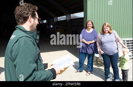 Nordstrandischmoor, Germania. 17 maggio 2021. Jan Philipp Albrecht (l-r, Bündnis 90/Die Grünen), ministro dell'ambiente dello Schleswig-Holstein, si trova di fronte a Ruth e Stefanie Kruse del Norderwarft, sull'Hallig Nordstrandischmoor, con notifica di finanziamento. Attualmente è in fase di espansione per diventare il primo tumulo di abitazioni a controllo climatico al mondo. Credit: Frank Molter/dpa/Alamy Live News Foto Stock