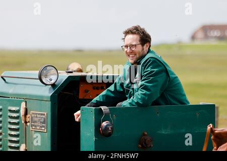 Nordstrandischmoor, Germania. 17 maggio 2021. Jan Philipp Albrecht (Bündnis 90/Die Grünen), ministro dell'ambiente dello Schleswig-Holstein, si trova su un carrello. Albrecht consegnò un sussidio per il Norderwarft sul Nordstrandischmoor Hallig. Attualmente è in fase di espansione per diventare il primo tumulo di abitazioni a controllo climatico al mondo. Credit: Frank Molter/dpa/Alamy Live News Foto Stock