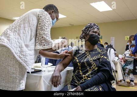 Johannesburg, Sudafrica. 17 maggio 2021. Una donna anziana riceve una dose di vaccino COVID-19 in un sito di vaccinazione a Johannesburg, Sudafrica, 17 maggio 2021. Il governo sudafricano ha ufficialmente lanciato la seconda fase del programma di vaccinazione COVID-19 per vaccinare le persone di età superiore ai 60 anni in tutto il paese. Credit: Yeshiel/Xinhua/Alamy Live News Foto Stock