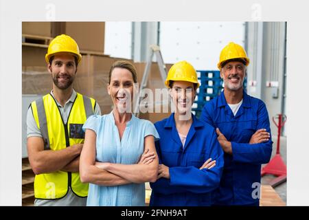 Composizione di sorridenti operai di magazzino con armi barrato Foto Stock
