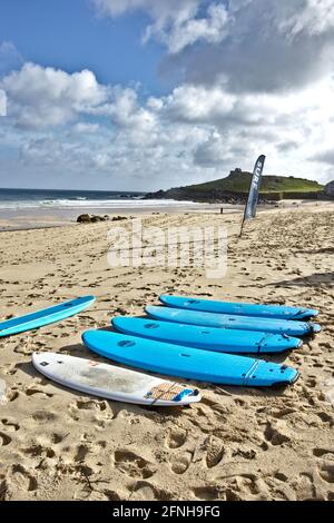 Tavole da surf turchesi allineate sulla spiaggia di Porthmeor Cornwall Foto Stock