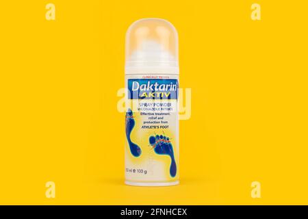 Una lattina di Daktarin ACTIV su sfondo giallo. Foto Stock