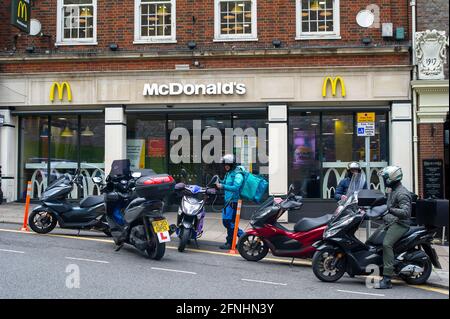 Windsor, Berkshire, Regno Unito. 16 maggio 2021. Consegna autisti al di fuori del McDonald's. Nonostante la nuova variante indiana del Covid-19 sia arrivata nel Regno Unito, la prossima fase della tabella di marcia delle restrizioni di blocco del Covid-19 sarà revocata in Inghilterra da domani lunedì 17 maggio 2021. Il Professor Chris Whitty, Chief Medical Officer, ha avvertito che il Regno Unito potrebbe essere in grado di raggiungere un grande picco nei casi di Covid-19 a causa della variante indiana. Credito: Maureen McLean/Alamy Foto Stock