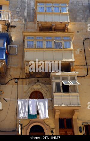 Valletta. Malta. Città vecchia. Tipica architettura maltese: Balconi in legno recintati. Asciugando loundry all'esterno. Foto Stock