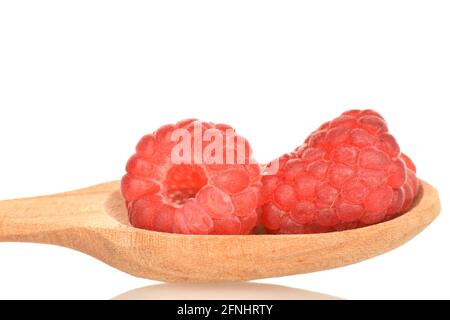 Due lamponi rossi maturi con un cucchiaio di legno, primo piano, isolati su bianco. Foto Stock