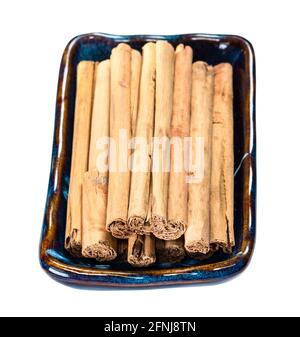 vista finale di quills di erba premiumin ceylon cannella in scodella in ceramica tagliata su sfondo bianco Foto Stock