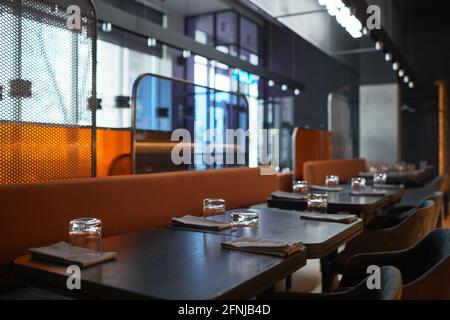 Diversi pannelli testurizzati tra i posti a sedere nel bar bistrot: Tavoli serviti con tovaglioli e bicchieri Foto Stock
