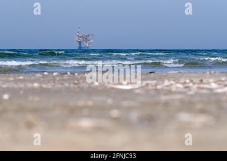 Ameland, Olanda aprile 20,2021-NAM, piattaforma offshore con spiaggia, sabbia e surf. Estrazione di gas naturale nella regione di Wadden-Mare del Nord Foto Stock