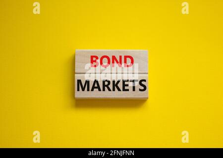 Simbolo dei mercati obbligazionari. Blocchi di legno con le parole 'Bond mercati' su uno sfondo giallo bello, spazio di copia. Concetto di mercato commerciale e obbligazionario. Foto Stock