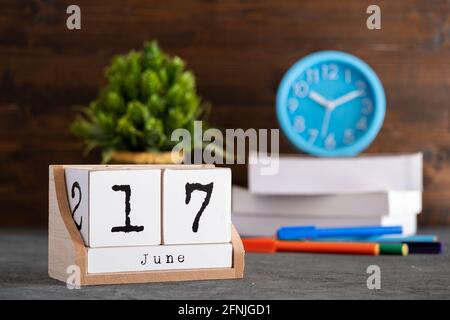 17 giugno. Giugno 17 calendario cubo di legno con oggetti sfocati sullo sfondo. Foto Stock