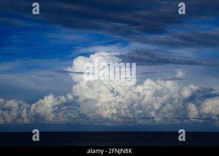 Vista panoramica delle acque oceaniche linea orizzonte con drammatico cumulo temporale paesaggio nuvoloso in blu cielo sfondo. Foto Stock