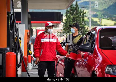 Passo, Narino, Colombia. 16 maggio 2021. Un lavoratore della stazione di rifornimento riempie un'auto con poco carburante, come il suo proprietario guarda il conteggio di carburante in mezzo a massicce carenze di carburante a causa dell'aumento delle proteste in Colombia contro la brutalità della polizia e casi di abuso che hanno causato 16 donne in stato di abuso e più di 40 morti negli ultimi 20 giorni di sciopero nazionale anti-governativo, a Pato, Narino il 16 maggio 2021 Credit: Camilo Erasso/LongVisual/ZUMA Wire/Alamy Live News Foto Stock