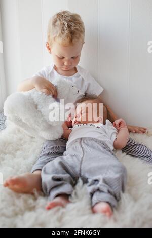 il fratello maggiore gioca con il fratello minore negli stessi vestiti Foto Stock