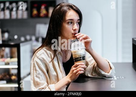 ragazza in una caffetteria con caffè da andare Foto Stock