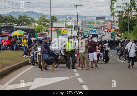 I poliziotti di transito colombiani aiutano i civili in auto bloccate sul blocco tornare indietro e utilizzare camini alternativi come i camionisti nazionali sciopero a Dosquebradas- Santa Rosa de Cabal cerchio di traffico Risaralda, Colombia 17 maggio, 2021. Come parte delle proteste anti-governative in Colombia, che hanno portato almeno 40 morti in 20 giorni di manifestazione contro la brutalità della polizia, e le riforme sanitarie e fiscali del presidente Ivan Duque. Foto Stock