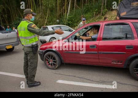 I poliziotti di transito colombiani aiutano i civili in auto bloccate sul blocco tornare indietro e utilizzare camini alternativi come i camionisti nazionali sciopero a Dosquebradas- Santa Rosa de Cabal cerchio di traffico Risaralda, Colombia 17 maggio, 2021. Come parte delle proteste anti-governative in Colombia, che hanno portato almeno 40 morti in 20 giorni di manifestazione contro la brutalità della polizia, e le riforme sanitarie e fiscali del presidente Ivan Duque. Foto Stock