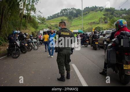 I poliziotti di transito colombiani aiutano i civili in auto bloccate sul blocco tornare indietro e utilizzare camini alternativi come i camionisti nazionali sciopero a Dosquebradas- Santa Rosa de Cabal cerchio di traffico Risaralda, Colombia 17 maggio, 2021. Come parte delle proteste anti-governative in Colombia, che hanno portato almeno 40 morti in 20 giorni di manifestazione contro la brutalità della polizia, e le riforme sanitarie e fiscali del presidente Ivan Duque. Foto Stock