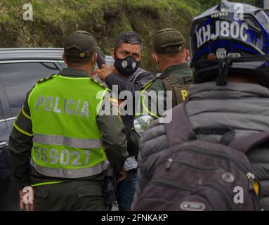 Dosquebradas, Risaralda, Colombia. 17 maggio 2021. I poliziotti di transito colombiani aiutano i civili in auto bloccate sul blocco tornare indietro e utilizzare camini alternativi come i camionisti nazionali sciopero a Dosquebradas- Santa Rosa de Cabal cerchio di traffico Risaralda, Colombia 17 maggio, 2021. Come parte delle proteste anti-governative in Colombia, che hanno portato almeno 40 morti in 20 giorni di manifestazione contro la brutalità della polizia, e le riforme sanitarie e fiscali del presidente Ivan Duque. Credit: Sebastian Osorio/LongVisual/ZUMA Wire/Alamy Live News Foto Stock