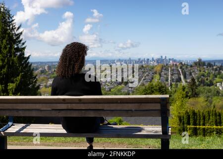 Donna adulto di mezza età seduto fuori in un parco Foto Stock