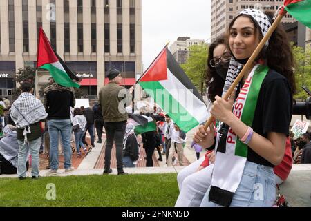 Dayton, Stati Uniti. 17 maggio 2021. Una donna con bandiera palestinese sostiene una Palestina libera. I dimostranti si incontrano a Dayton, Ohio, nella piazza del tribunale, per radunare e marciare contro lo sciopero aereo di Israele su Gaza e l'occupazione della Palestina. Secondo il ministero della salute gestito da Hamas, il bilancio complessivo delle vittime si aggira intorno a 200, tra cui 59 bambini e 35 donne, con almeno 1,305 feriti. Credit: SOPA Images Limited/Alamy Live News Foto Stock