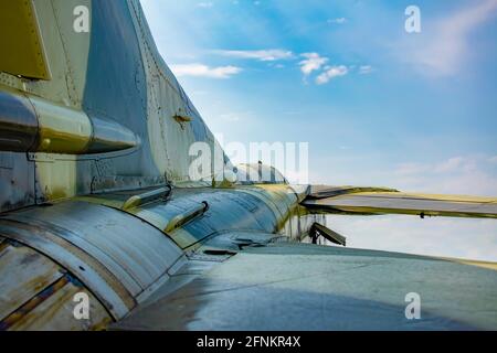 vista della fusoliera di un aereo militare da combattimento in camuffamento di colore verde dal lato posteriore del motore ugelli contro un cielo blu con nuvole Foto Stock