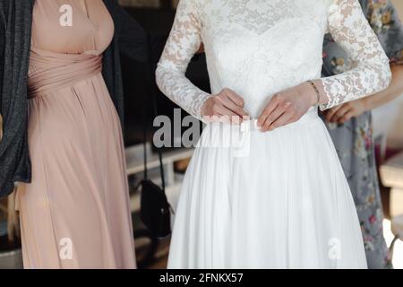 Sposa si prepara al mattino, indossando il suo vestito da sposa Foto Stock