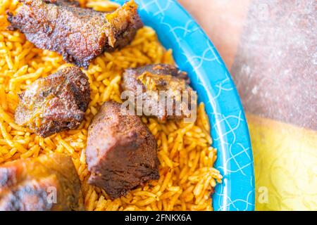 Riso nigeriano Jollof accompagnato da carne fritta Foto Stock