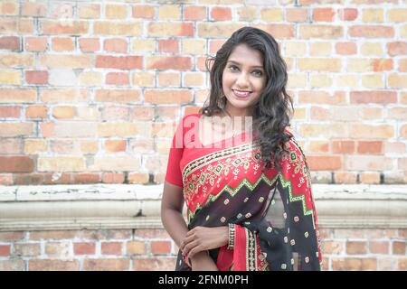 Ritratto di una bella donna indiana sorridente con saree rosse. Spazio di copia. Foto Stock