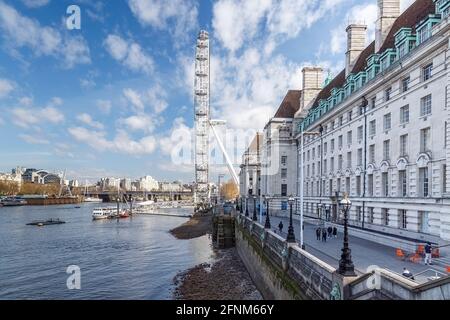 Vista dal ponte di Westminster che cattura, London Eye, County Hall, il fiume Tamigi a bassa marea e Hungerford Bridge in una giornata nuvolosa. Foto Stock