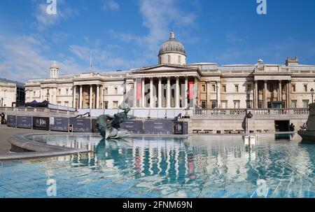La Galleria Nazionale si riflette nelle acque blu ancora di una delle fontane di Piazza Trafalgar, che riempie l'immagine in primo piano. Foto Stock