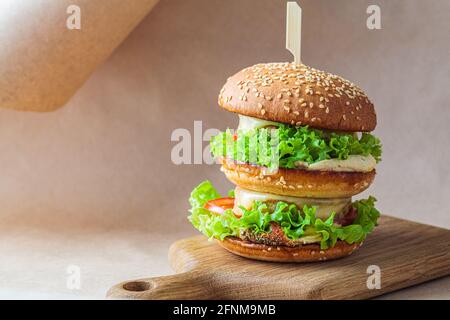 Hamburger vegano con verdure e hummus, fondo kraft marrone. Riciclaggio degli imballaggi alimentari, concetto zero rifiuti. Concetto di dieta a base di piante. Foto Stock