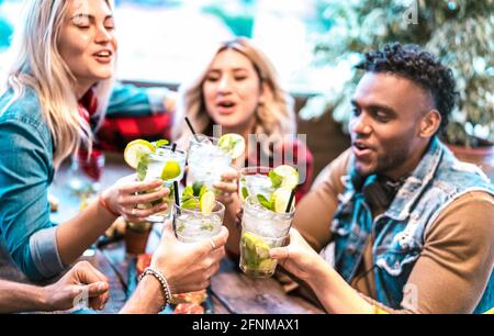 I migliori amici gustano bevande mojito presso il cocktail bar ristorante alla moda - concetto del tempo di festa con i giovani che hanno bevuto divertimento bere su happy hour Foto Stock