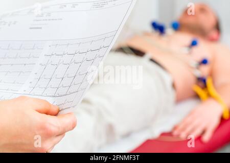 Medico donna analizzando elettrocardiogramma ECG del paziente in ospedale Foto Stock