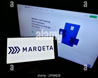 Persona che detiene smartphone con il logo della società americana di servizi finanziari Marqeta Inc. Sullo schermo di fronte al sito web. Mettere a fuoco il display del telefono. Foto Stock