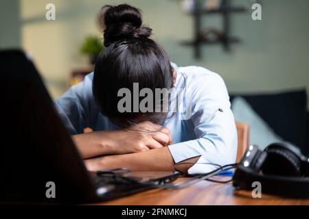 Giovane donna d'affari che dorme chiudendo il laptop mentre lavora, concetto di nuovo burnout normale, oltre o tardi lavoro notturno a casa durante il coronavirus covid Foto Stock