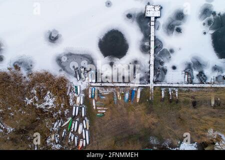 Immagine aerea su banchina di legno e barche da pesca in congelato fiume Foto Stock