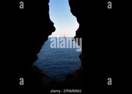 BIRZEBBUGA, MALTA - 10 giu 2015: La vista dalla grotta marina, formata da agenti atmosferici / erosione del calcare maltese. L'uscita della grotta si affaccia sul mare Foto Stock