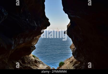 BIRZEBBUGA, MALTA - 10 giu 2015: La vista dalla grotta marina, formata da agenti atmosferici / erosione del calcare maltese. L'uscita della grotta si affaccia sul mare Foto Stock