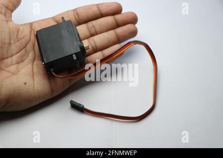 Micro servomeccanismo con coppia elevata controllata digitalmente da micro controller con ingranaggi metallici tenuti in mano Foto Stock