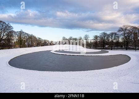 La Landform di Charles Jencks (2002) nella neve, un paesaggio scolpito alla Scottish National Gallery of Modern Art One di Edimburgo, Scozia, Regno Unito Foto Stock