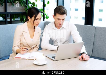 I colleghi discutono durante la riunione aziendale. Uomini d'affari al lavoro Foto Stock