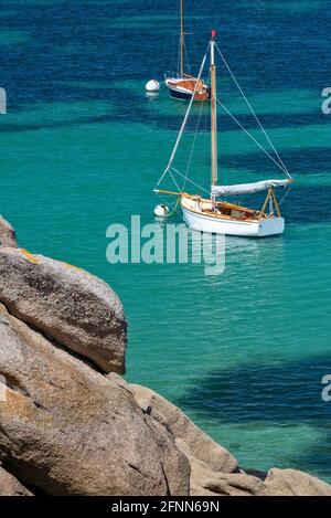 Barche a vela e acqua trasparente sulla spiaggia di Coz-Pors a Tregastel, Côtes d'Armor, Bretagna, Francia Foto Stock