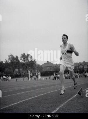 1954, storico, un concorrente maschile fuori correre su una pista di erba in una giornata di sport di servizio civile, Inghilterra, Regno Unito, un evento sportivo dilettante ma comunque competitivo. Foto Stock