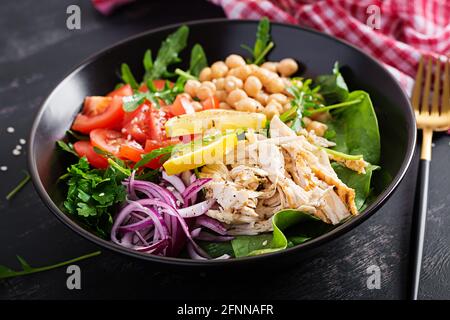Piatto di ciotola Buddha con filetto di pollo, ceci, pomodori, cipolla rossa, insalata verde fresca e sesamo di semi. Alimentazione sana ed equilibrata. Foto Stock