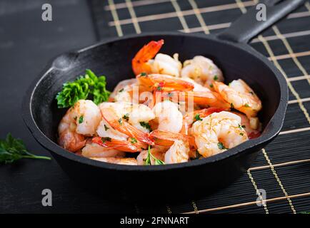 Gamberi fritti. Gamberetti arrosto in padella con limone, prezzemolo e aglio. Foto Stock