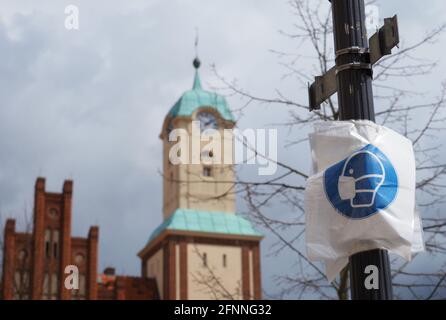 07 maggio 2021, Brandeburgo, Wittstock/Dosse: Fogli sminuzzati con immagini stilizzate su un lampione di fronte al municipio ricordano ai passanti l'obbligo di indossare una maschera sulla piazza del mercato. Foto: Soeren Stache/dpa-Zentralbild/dpa Foto Stock