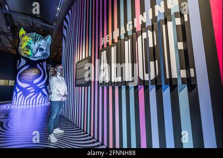 Londra, Regno Unito. 18 maggio 2021. Reinventare Alice con il Cheshire Cat - un'installazione d'arte digitale ispirata al vetro ‘look', che incoraggia i visitatori a immaginare le proprie meraviglie - Alice: Curiouser e Curiouser mostra al V&A, si apre come blocco facilita ulteriormente. Celebrando la storia iconica, fantasiosa e stimolante, il V&A è il primo museo ad esplorare appieno l'impatto culturale di Alice nel paese delle meraviglie e la sua continua ispirazione per i migliori creativi, da Salvador Dalí e Yayoi Kusama, ai Beatles, Vivienne Westwood e Little Sitz. La mostra è stata progettata da un premiato designer Foto Stock