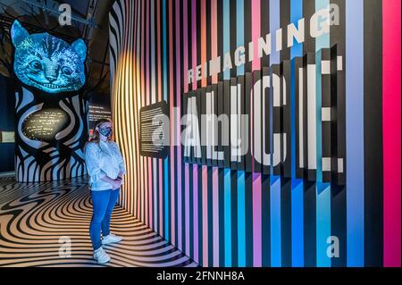 Londra, Regno Unito. 18 maggio 2021. Reinventare Alice con il Cheshire Cat - un'installazione d'arte digitale ispirata al vetro ‘look', che incoraggia i visitatori a immaginare le proprie meraviglie - Alice: Curiouser e Curiouser mostra al V&A, si apre come blocco facilita ulteriormente. Celebrando la storia iconica, fantasiosa e stimolante, il V&A è il primo museo ad esplorare appieno l'impatto culturale di Alice nel paese delle meraviglie e la sua continua ispirazione per i migliori creativi, da Salvador Dalí e Yayoi Kusama, ai Beatles, Vivienne Westwood e Little Sitz. La mostra è stata progettata da un premiato designer Foto Stock